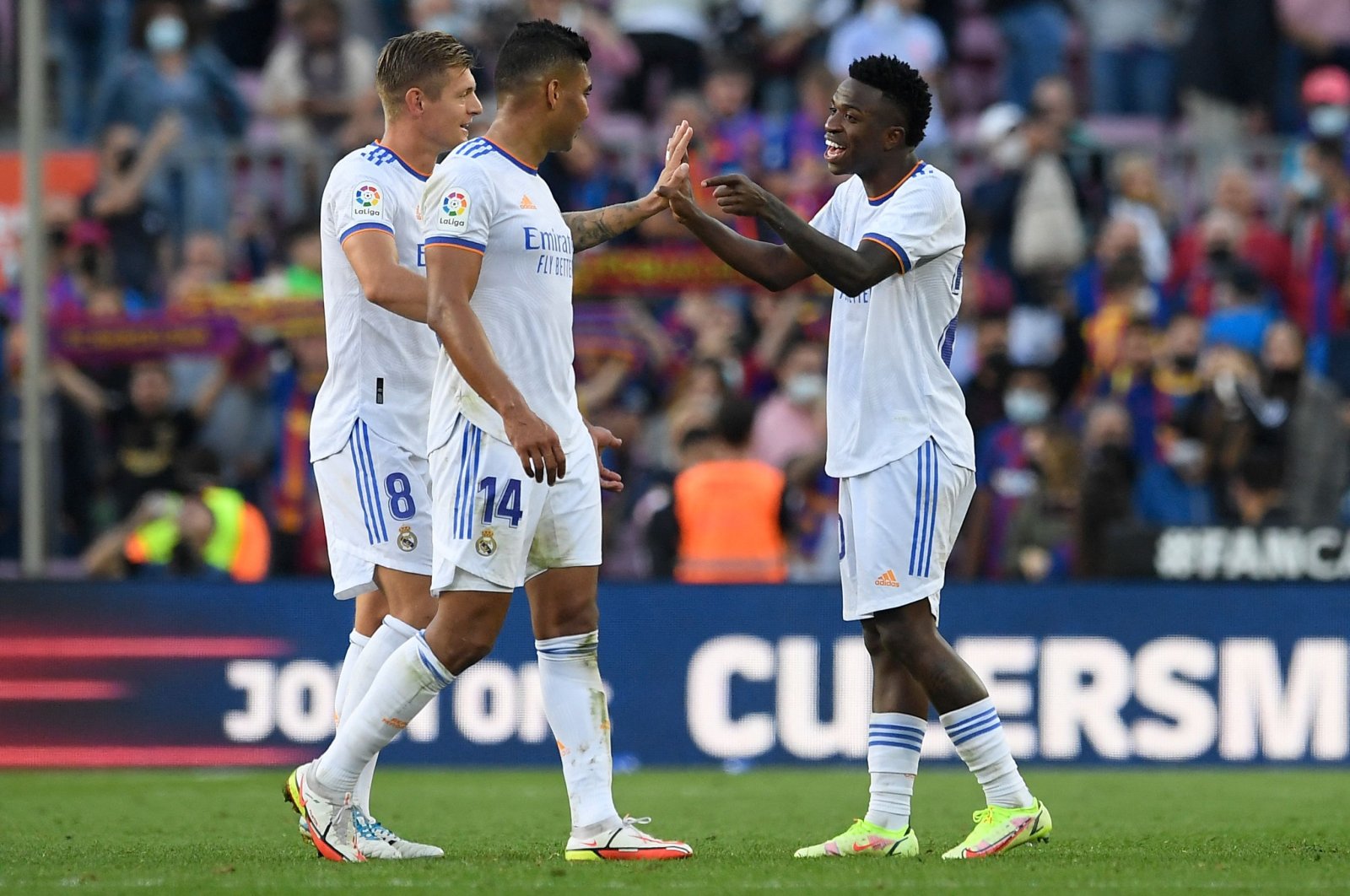 Real Madrid's German midfielder Toni Kroos (L), Real Madrid's Brazilian midfielder Casemiro (C) and Real Madrid's Brazilian forward Vinicius Junior celebrate their win at the end of the Spanish League football match between FC Barcelona and Real Madrid CF at the Camp Nou stadium in Barcelona, Spain, Oct. 24, 2021. (AFP Photo)