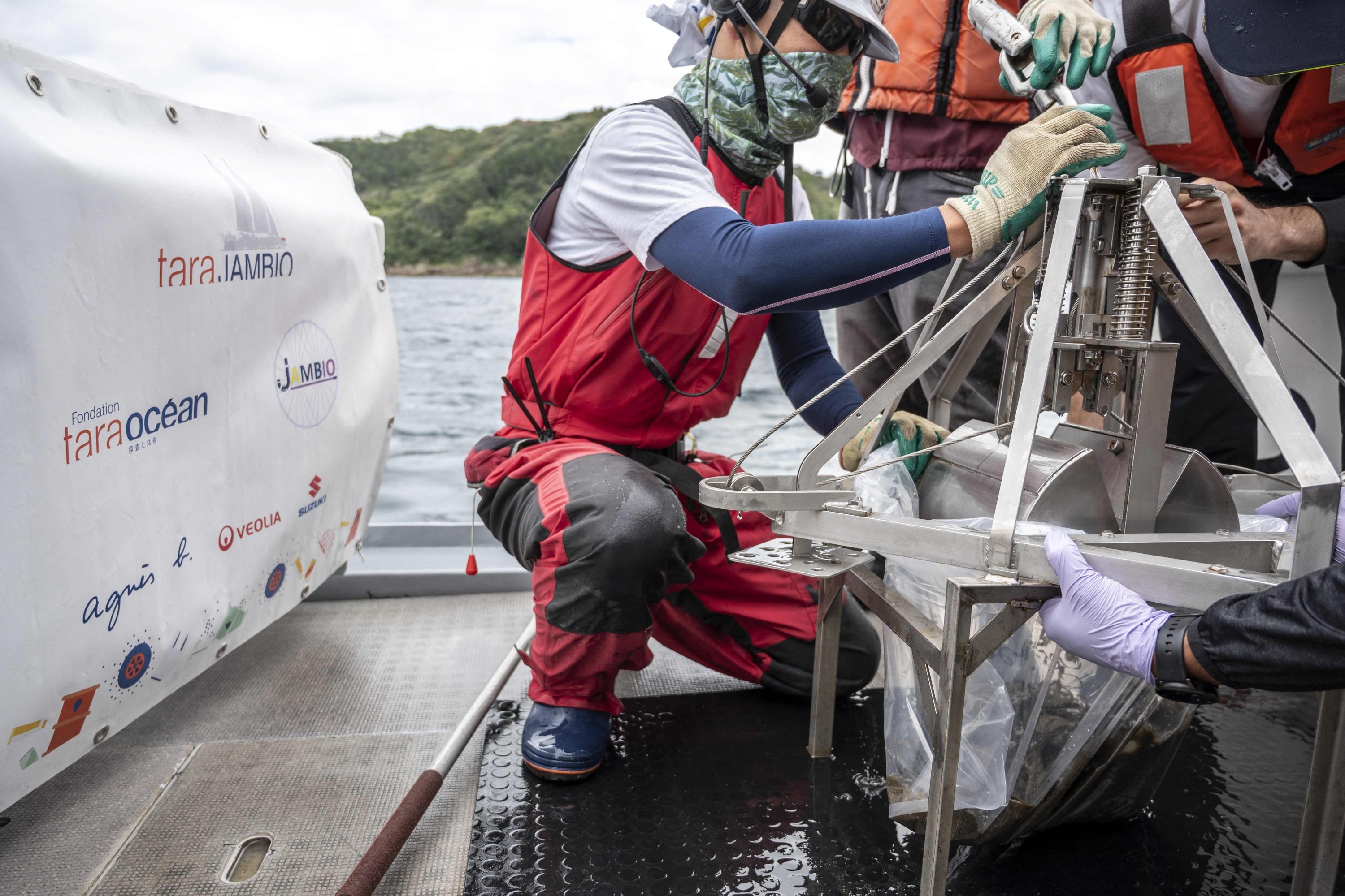 Researchers prepare to take sediment samples collected from a "Smith-McIntyre" grab machine during a joint project of the French Tara Ocean Foundation and Japanese marine-station network Jambio, onboard a boat off the coast of Shimoda, Shizuoka Prefecture, Japan, Oct. 14, 2021. (AFP Photo)
