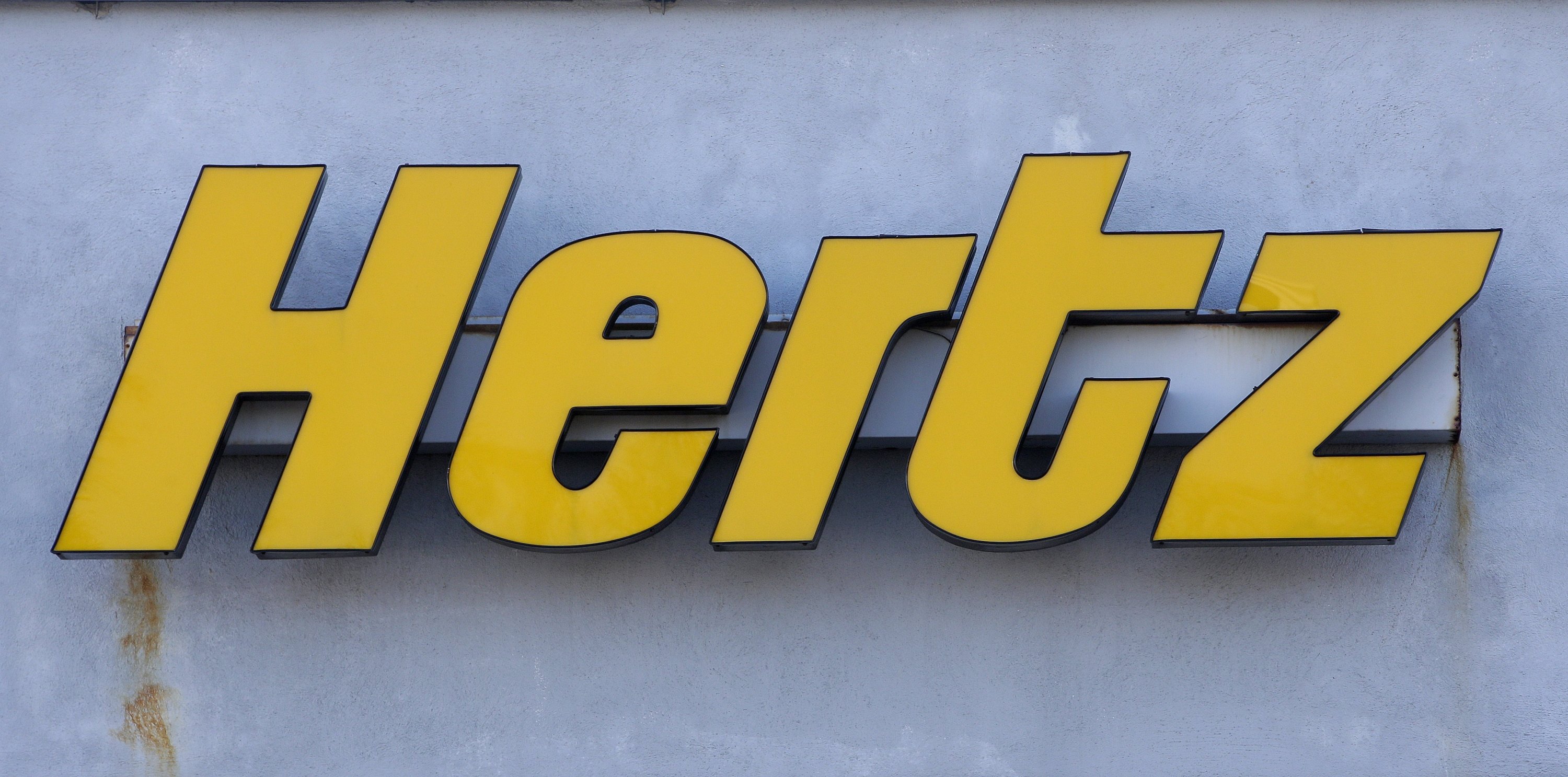 A Hertz rental car logo rests on the front of a Hertz location, in Boston, United States, Nov. 28, 2017. (AP Photo)