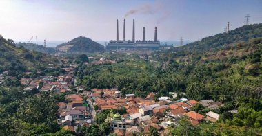 Village houses can be seen as smoke rises from the chimneys at the Suralaya coal power plant in Cilegon, Indonesia, Sept. 21, 2021. (AFP Photo)