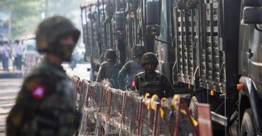 Soldiers stand next to military vehicles as people gather to protest against the military coup, in Yangon, Myanmar, February 15, 2021. (Reuters Photo)