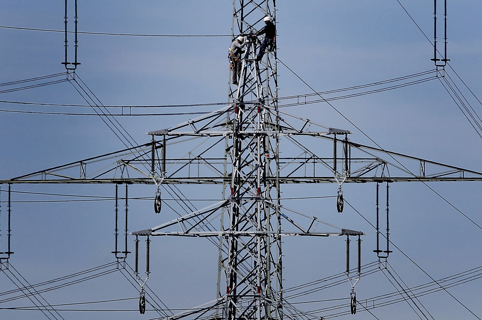 Workers of the German energy company RWE prepare power supply on a high power pylon in Moers, Germany, April 11, 2011. (AP Photo)