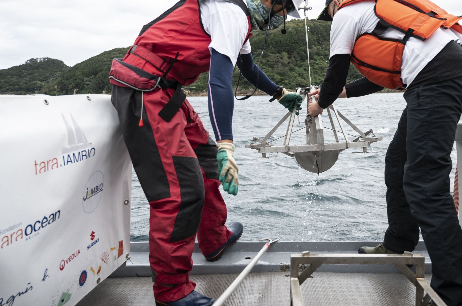 Researchers pull out a "Smith-McIntyre" grab machine collecting sediment samples during a joint project of the French Tara Ocean Foundation and Japanese marine-station network Jambio, on board a boat off the coast of Shimoda, Shizuoka Prefecture, Japan, Oct. 14, 2021. (AFP Photo)