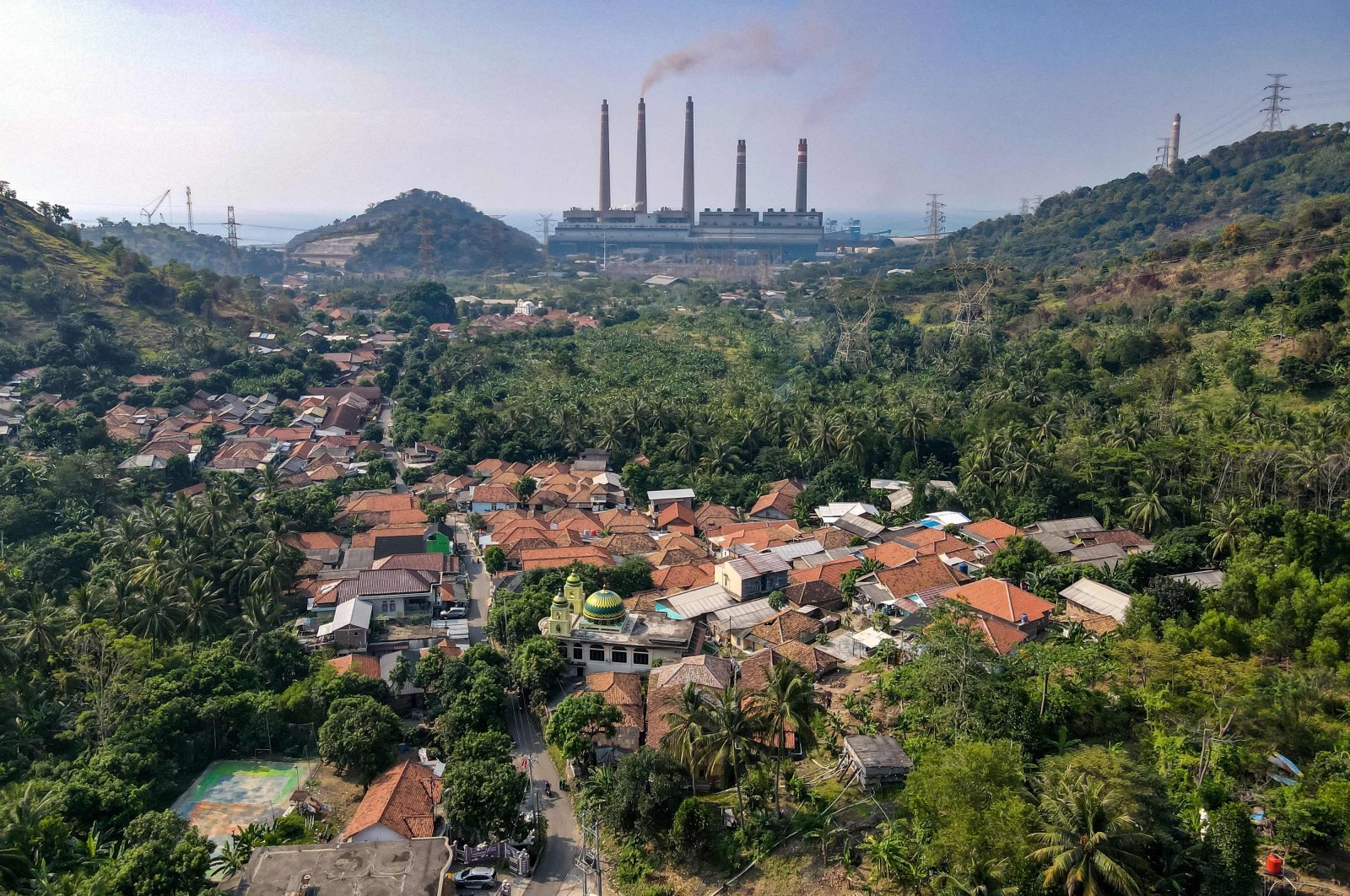 Village houses can be seen as smoke rises from the chimneys at the Suralaya coal power plant in Cilegon, Indonesia, Sept. 21, 2021. (AFP Photo)