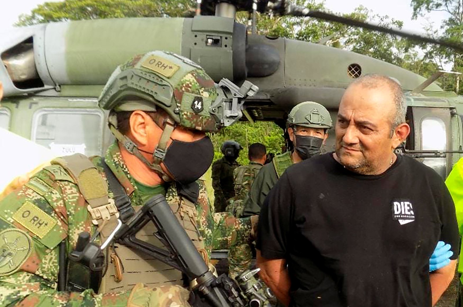 Dairo Antonio Usuga David, known as "Otoniel", is escorted by Colombian military personnel after being captured, in Turbo, Colombia, Oct. 23, 2021. (Colombian Defense Ministry via Reuters)