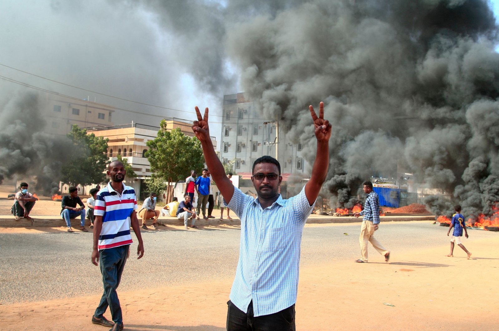 A Sudanese demonstrator flashes the victory sign during a demonstration in the capital Khartoum, on Oct. 25, 2021, to denounce overnight detentions by the army of members of Sudan's government. (AFP Photo)