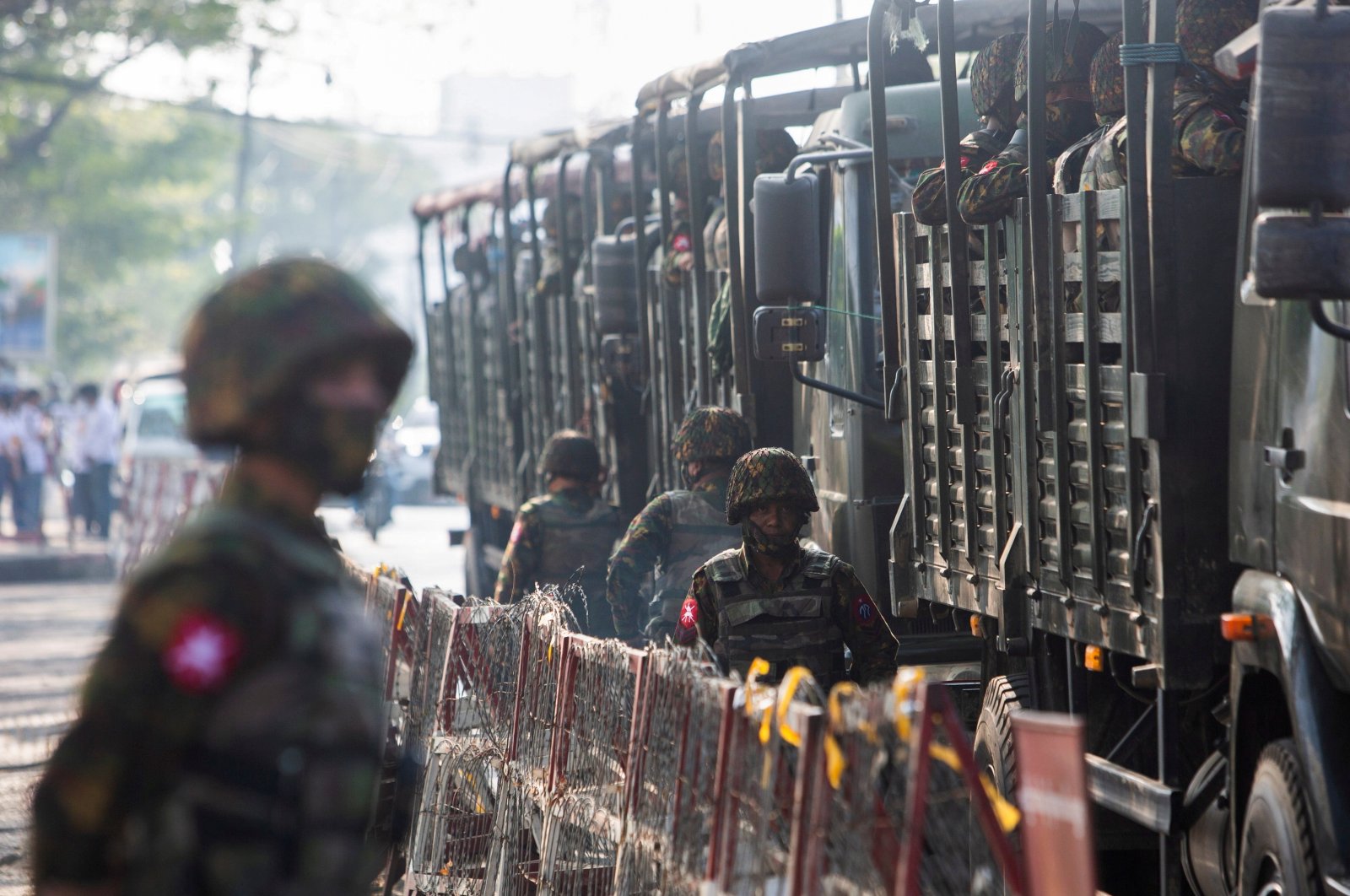Soldiers stand next to military vehicles as people gather to protest against the military coup, in Yangon, Myanmar, February 15, 2021. (Reuters Photo)