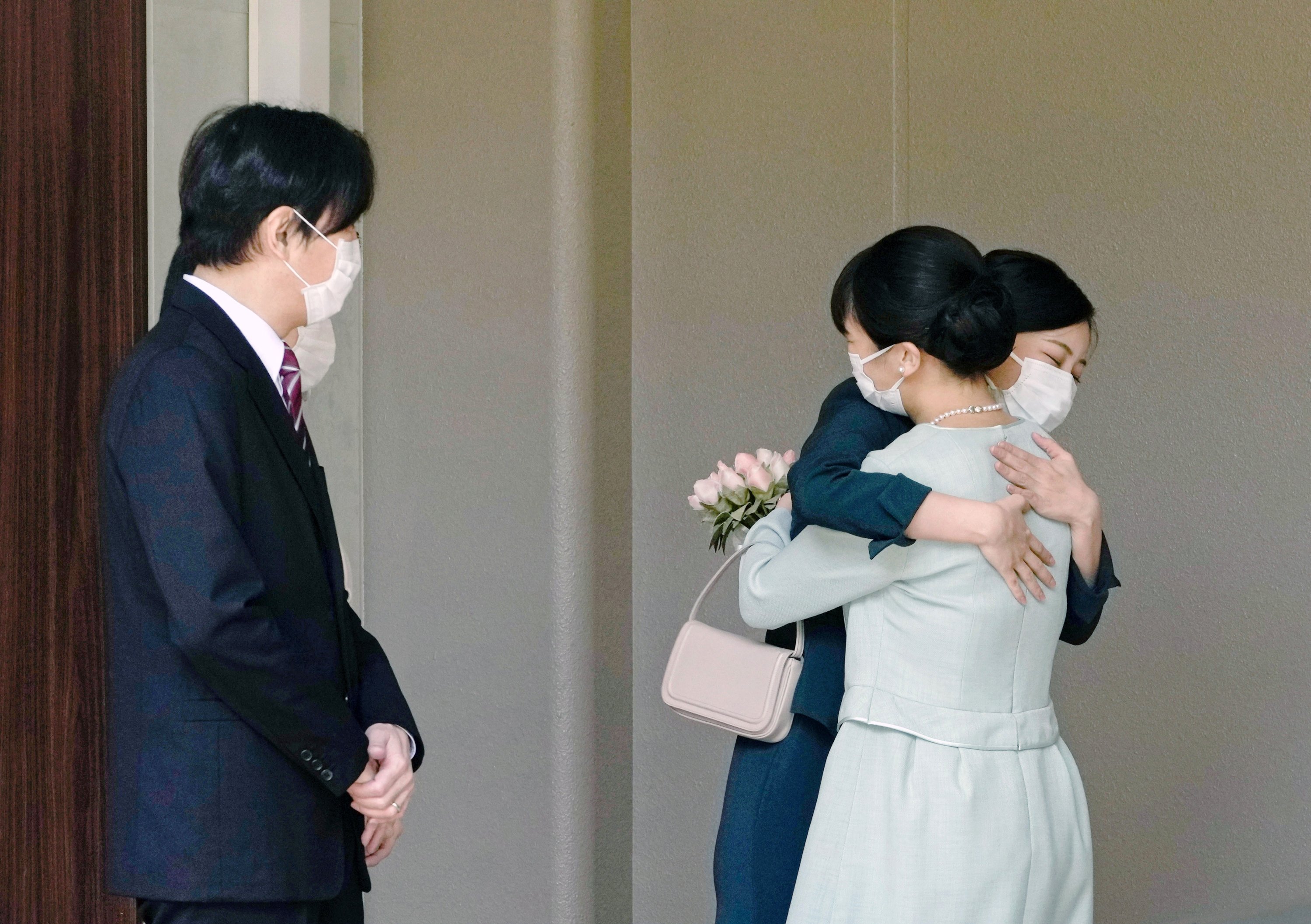 Princess Mako (R) is hugged by her sister Princess Kako (2-R) as she leaves her home in Tokyo, Japan, Oct. 26, 2021. (EPA-EFE Photo) 