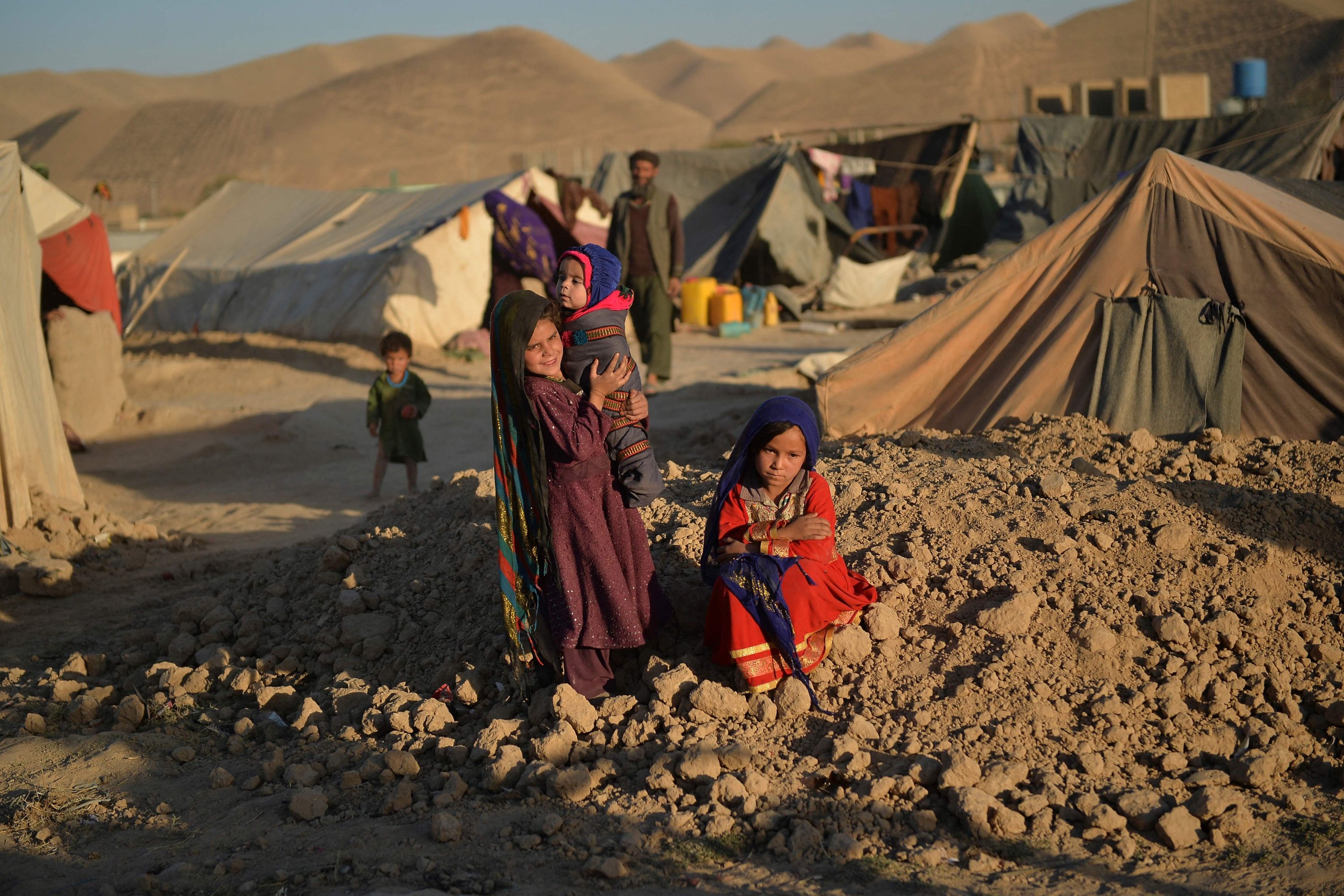 Asho (R), a little girl betrothed to a 23-year-old man to whose family they were indebted, sitting outside a tent at the Shamal Darya Internally Displaced People (IDP) camp in Qala-i-Naw, Badghis Province, Afghanistan, Oct. 14, 2021. (AFP Photo)