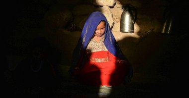 A little girl betrothed to a 23-year-old man to whose family they were indebted, sitting inside a tent at the Shamal Darya Internally Displaced People (IDP) camp in Qala-i-Naw, Badghis Province, Afghanistan, Oct. 14, 2021. (AFP Photo)