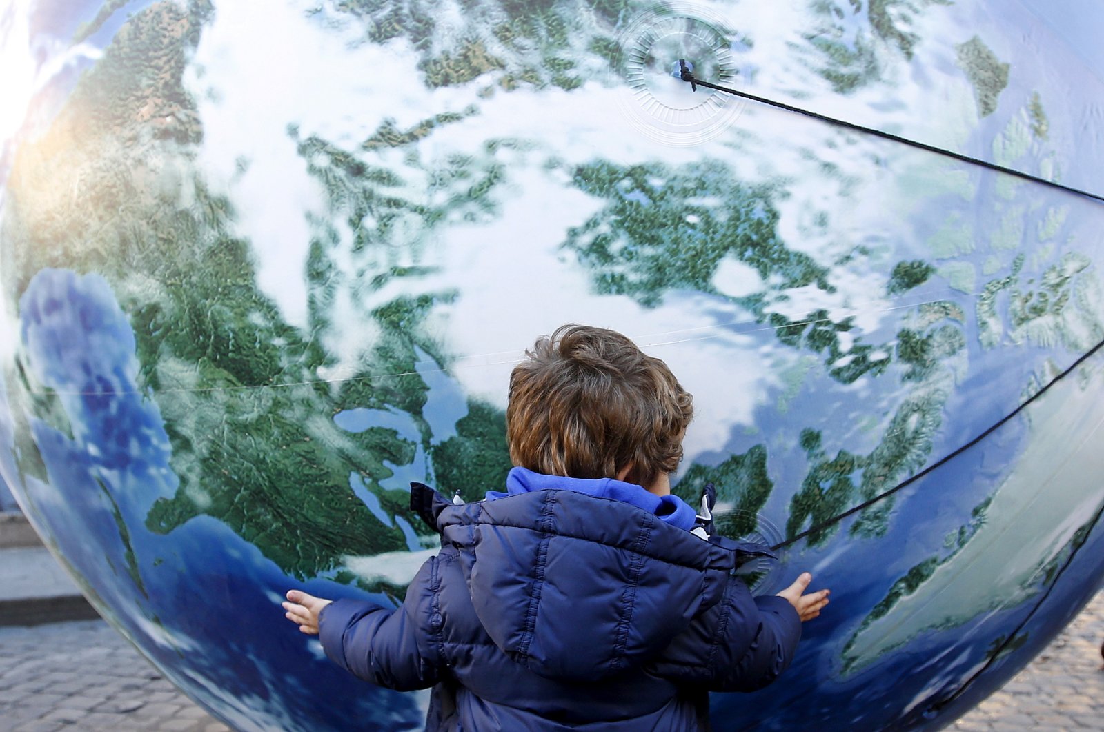  A child embraces a globe shaped balloon during a rally held ahead of the start of the 2015 Paris World Climate Change Conference, known as the COP21 summit, in Rome, Italy , Nov. 29, 2015. (Reuters Photo) 