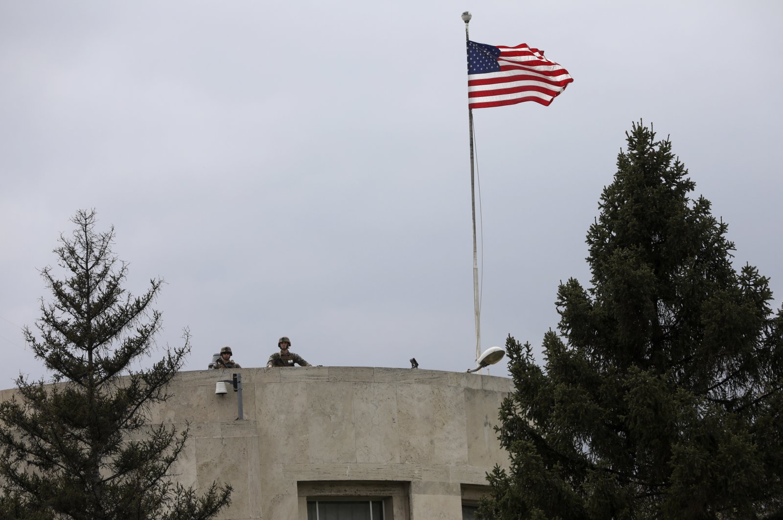U.S. soldiers stand guard on the rooftop of the U.S. Embassy as Turks stage a protest nearby in Ankara, Turkey, April 26, 2021. (AP Photo)