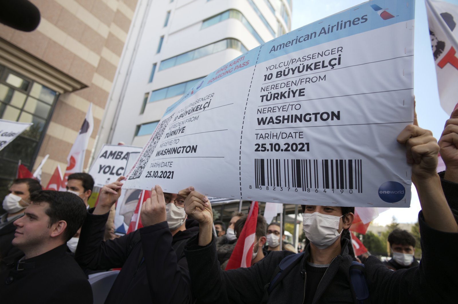 Members of a Turkish group hold a symbolic boarding pass for 10 foreign ambassadors as they stage a protest near the U. S. Embassy, in Ankara, Turkey, Oct. 25, 2021. (AP Photo)