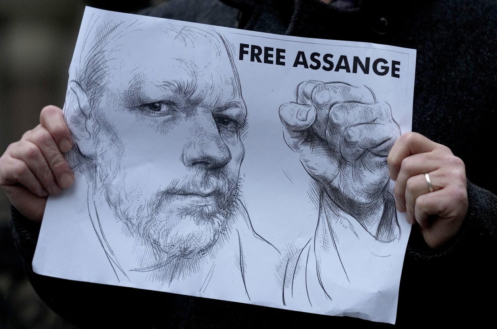 A demonstrator holds a poster as supporters of Julian Assange stage a demonstration outside the High Court in London, Britain, Oct. 27, 2021. (AP Photo)