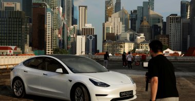 Tesla car owner Tim Shim, 42, films an "unboxing” video of his new Model 3 car in Singapore, Oct. 25, 2021. (Reuters Photo)