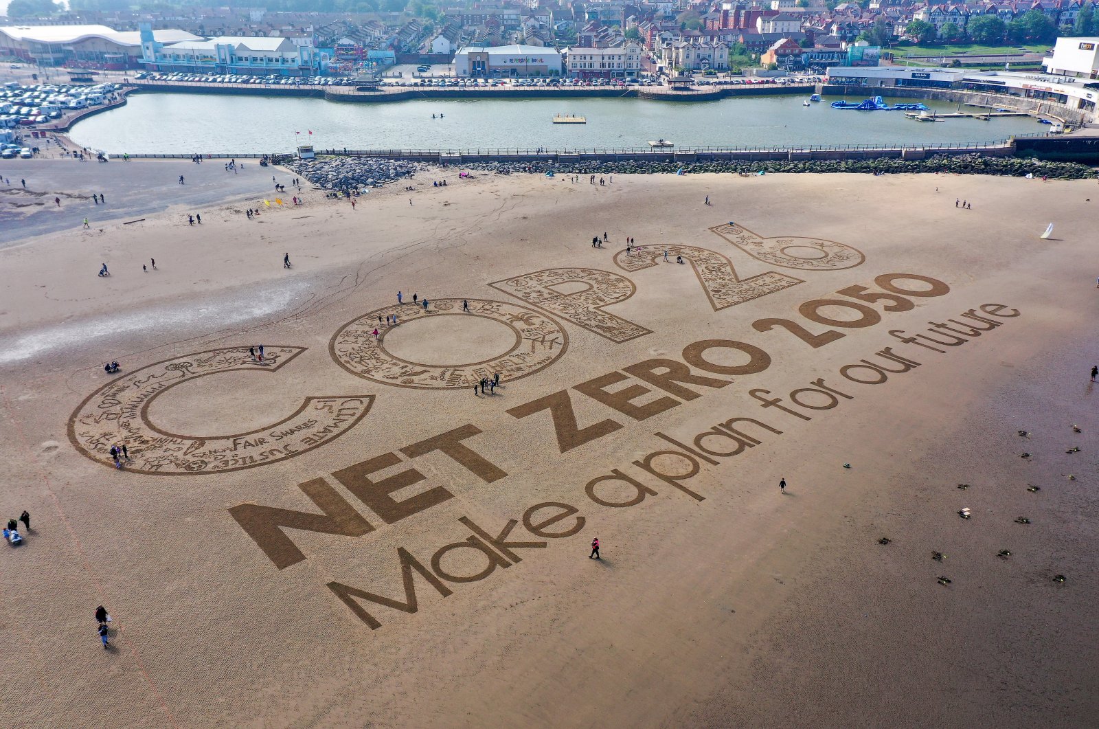 A giant sand artwork adorns New Brighton Beach to highlight global warming and the forthcoming COP26 global climate conference, Wirral, Merseyside, the U.K., May 31, 2021. (Photo by Getty Images)