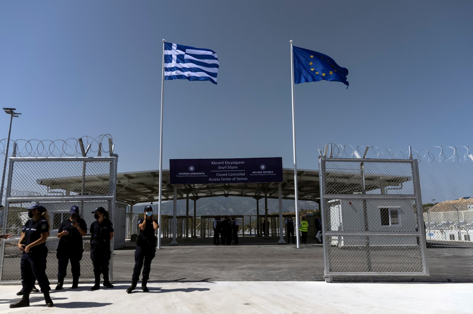 A Greek national flag and a European Union flag flutter inside a newly inaugurated compound-type migrant camp on the island of Samos, Greece, Sept. 18, 2021.  (REUTERS Photo)