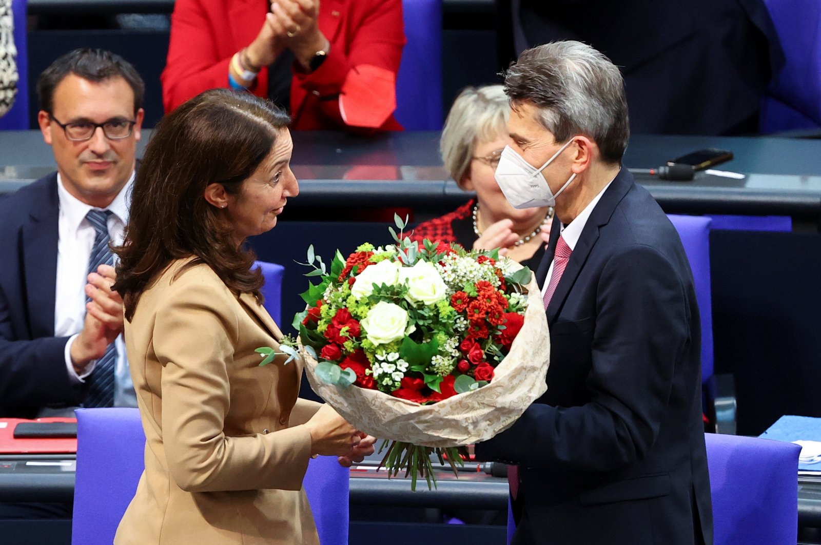 Aydan Özoğuz of the Social Democratic Party (SPD) receives flowers after being elected the Vice President during the inaugural session of the German lower house of Parliament Bundestag in Berlin, Germany, Oct. 26, 2021. (REUTERS/Fabrizio Bensch)
