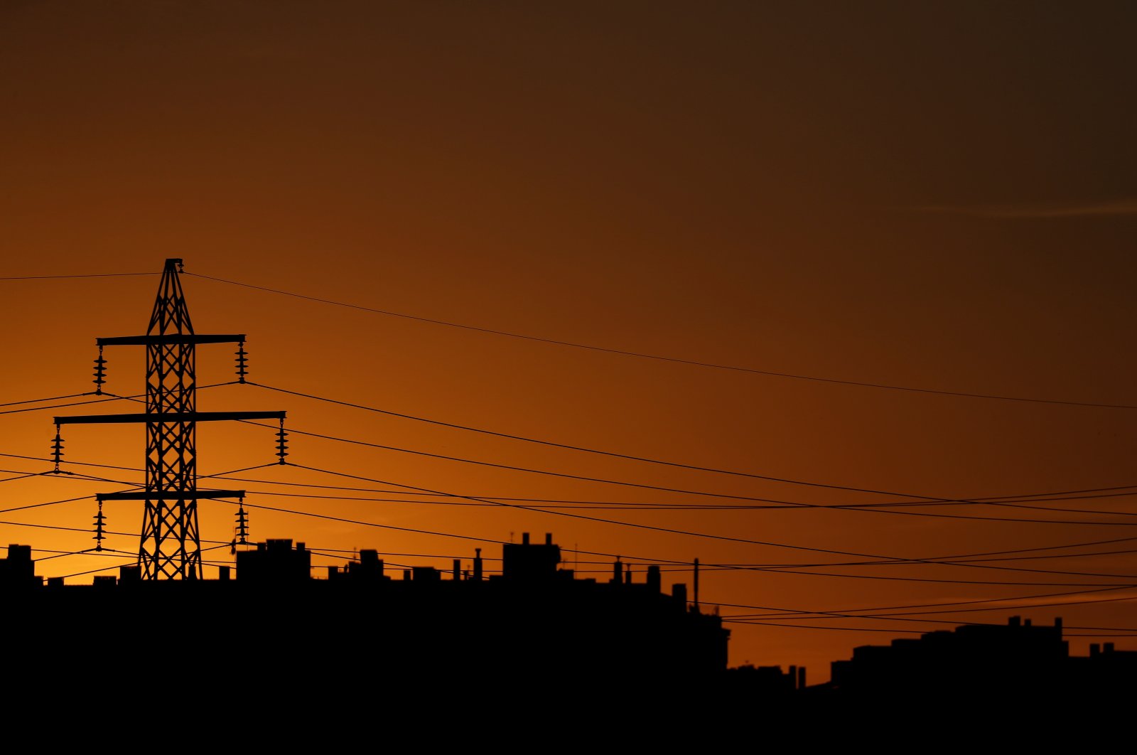 High-voltage power lines and an electricity pylon are seen at dusk outside Madrid, Spain, Sept. 29, 2021. (Reuters Photo)