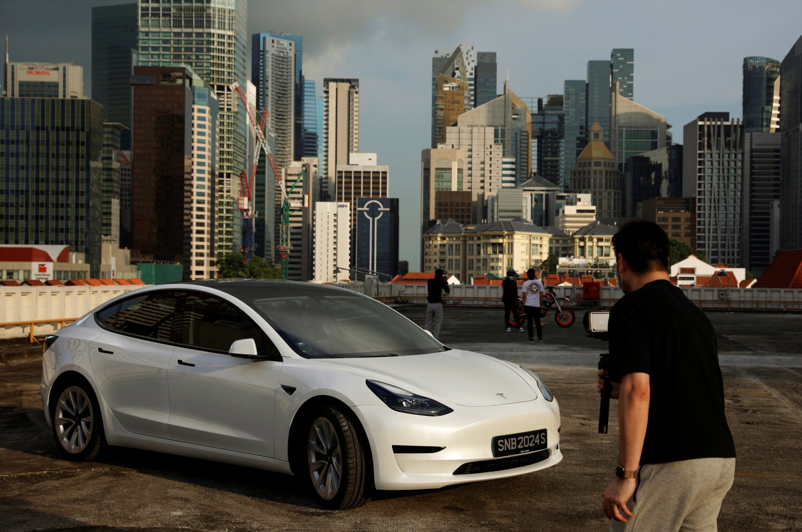 Tesla car owner Tim Shim, 42, films an "unboxing” video of his new Model 3 car in Singapore, Oct. 25, 2021. (Reuters Photo)
