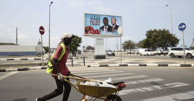A worker passes by the poster of President Recep Tayyip Erdoğan and President of Angola Joao Lourenco that reads "Together a Fairer World is Possible" in the capital Luanda, Angola, Oct. 19, 2021. (AA Photo)