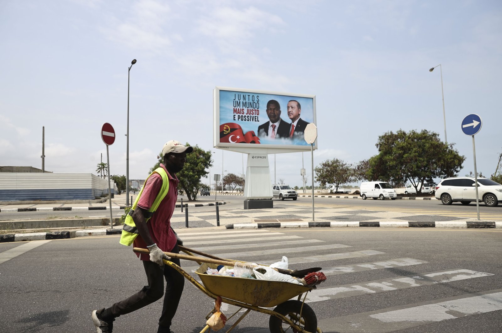 A worker passes by the poster of President Recep Tayyip Erdoğan and President of Angola Joao Lourenco that reads "Together a Fairer World is Possible" in the capital Luanda, Angola, Oct. 19, 2021. (AA Photo)