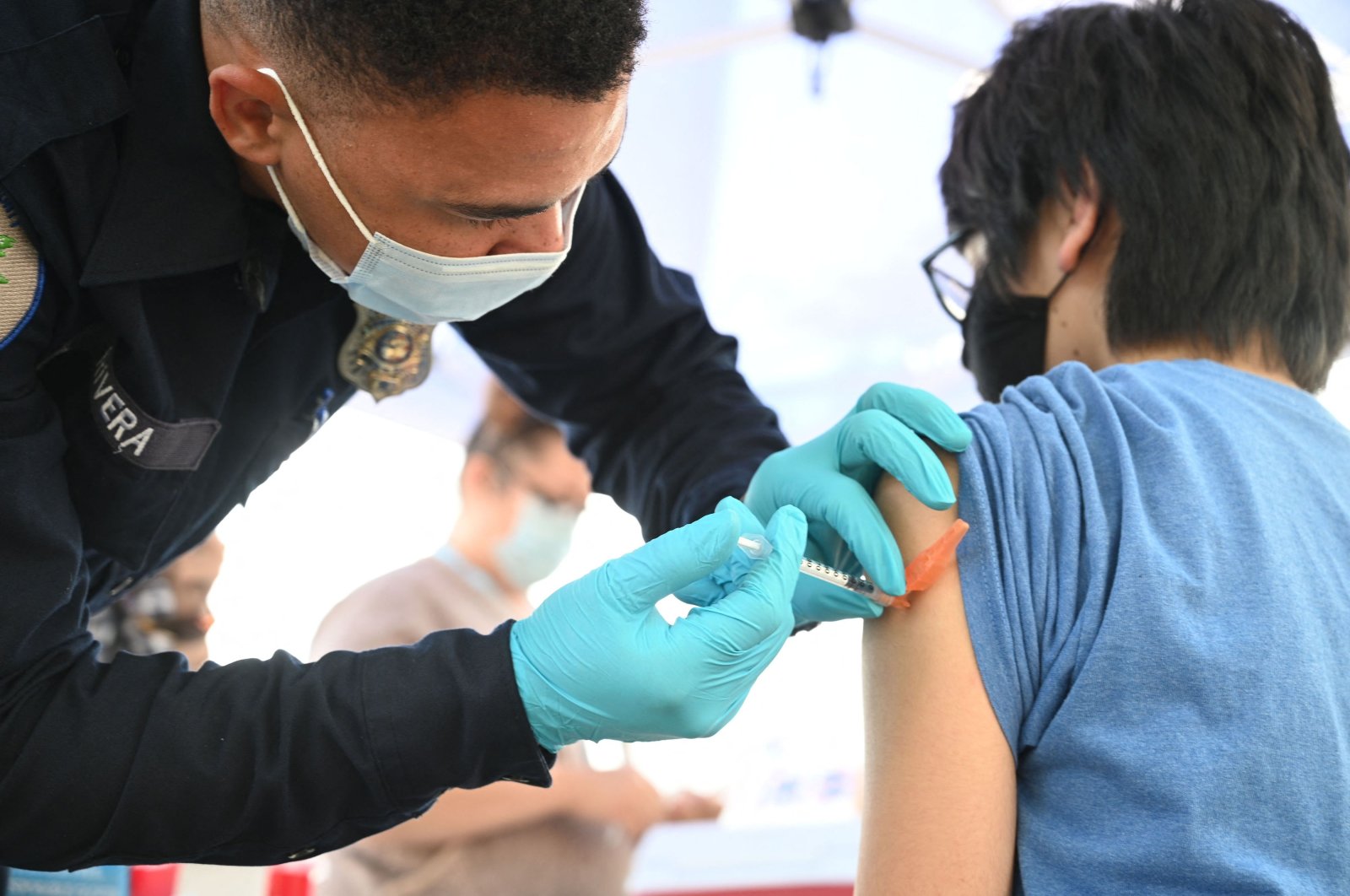 Brandon Rivera, a Los Angeles County emergency medical technician, gives a second dose of Pfizer-BioNTech COVID-19 vaccine to Aaron Delgado, 16, at a pop-up vaccine clinic in the Arleta neighborhood of Los Angeles, California, Aug. 23, 2021. (AFP Photo)