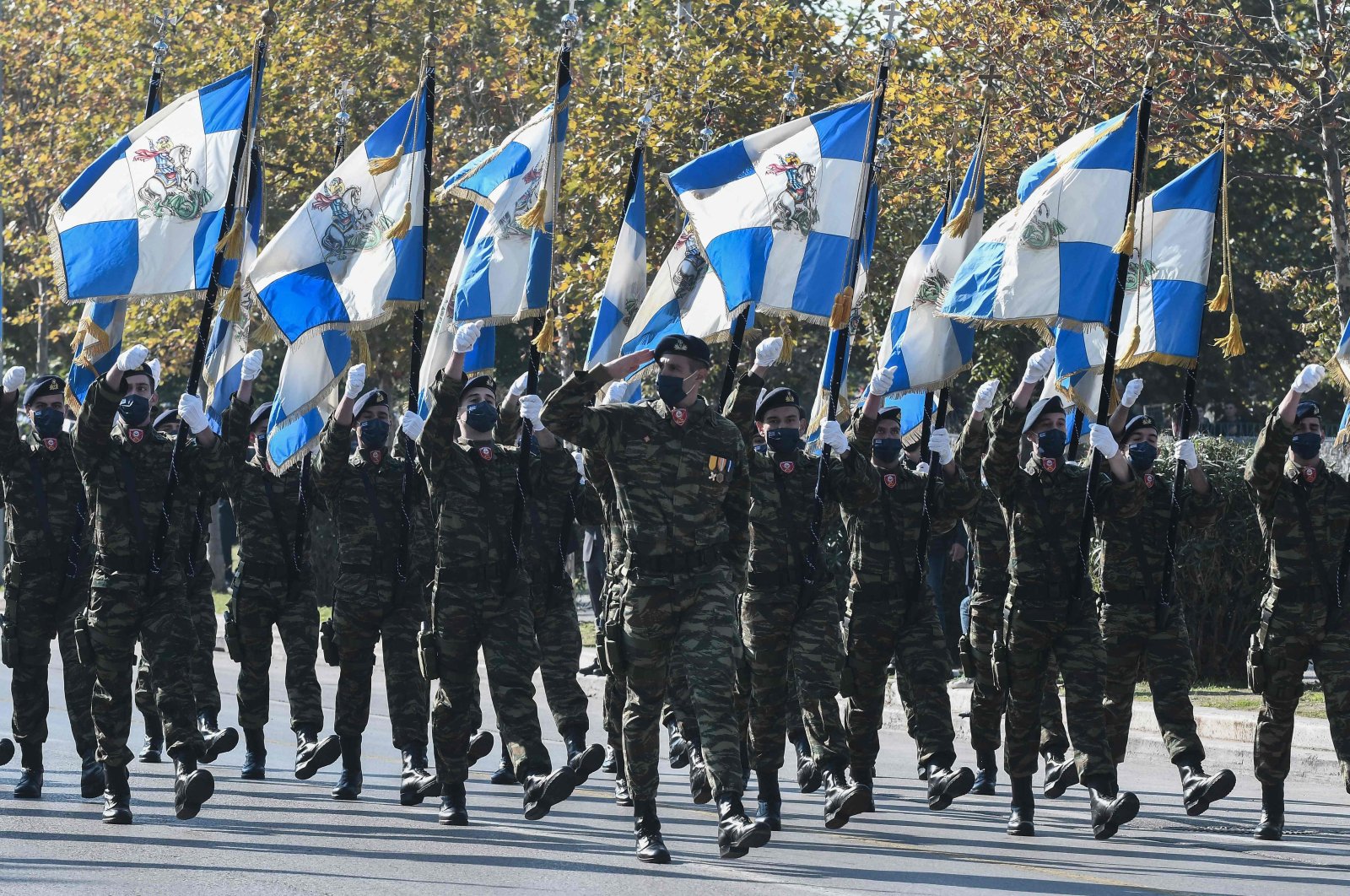 Greek soldiers hold flags as they attend a military parade during the celebrations marking Greece's National "Oxi" (No) Day, commemorating Greece's refusal to accept fascist Italy's ultimatum in 1940 during World War II, Thessaloniki, Greece, Oct. 28, 2021. (AFP Photo)