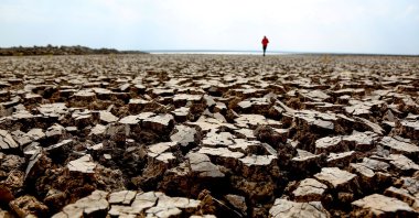 A person walks along cracks at the partly dried up Devegeçidi Dam, northwest of drought-stricken Diyarbakir, Turkey, Oct. 29, 2021. (Reuters Photo)