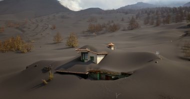 A house is covered by ash from a volcano as it continues to erupt on the Canary island of La Palma, Spain, Oct. 30, 2021. (AP Photo)