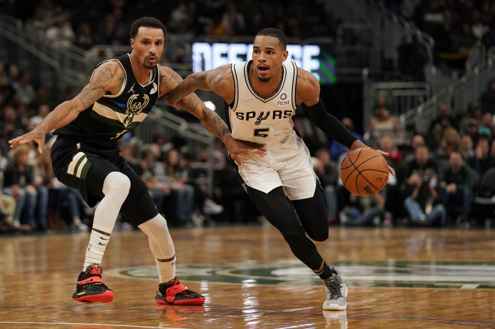 San Antonio Spurs Dejounte Murray (R) dribbles the ball against Milwaukee Bucks' George Hill (L) in the second half at Fiserv Forum, Milwaukee, Wisconsin, U.S., Oct. 30, 2021. (AFP Photo)