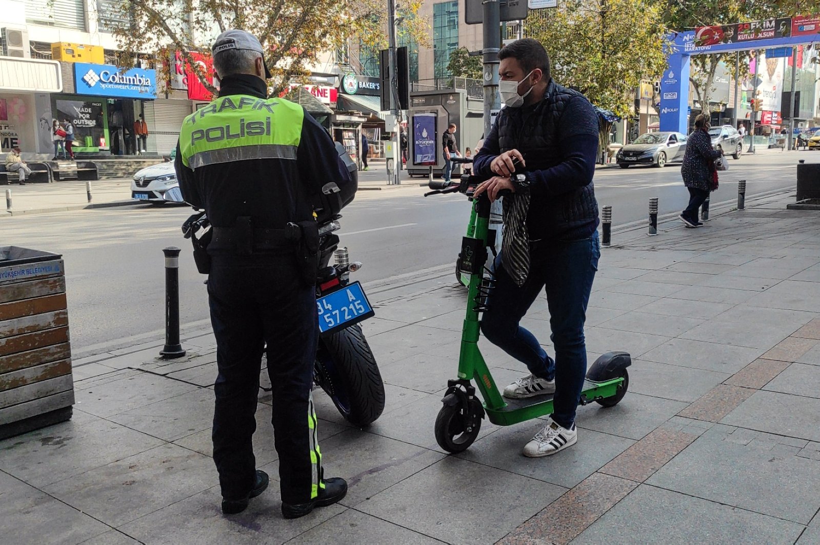 A traffic police officer in Istanbul fines a scooter driver for risky behavior in city's famous Baghdad Avenue, Istanbul, Turkey on Oct. 31, 2021 (AA Photo)