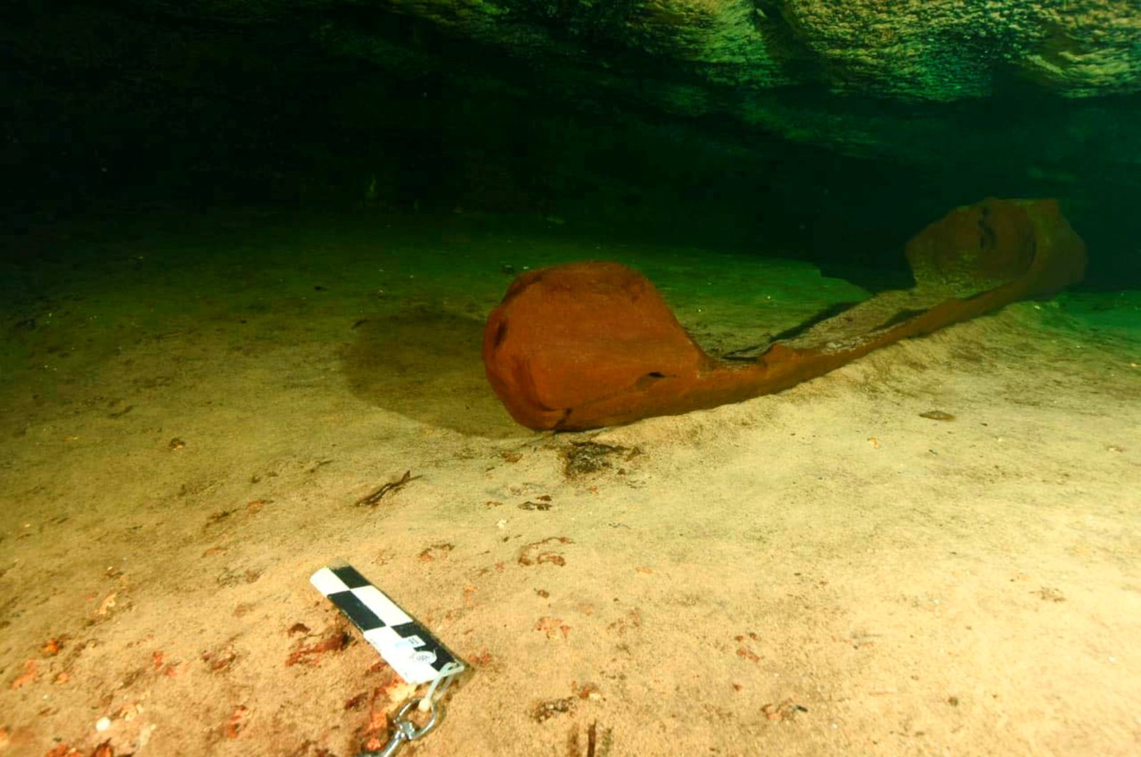 A wooden canoe used by the ancient Maya and believed to be over a thousand years old is pictured in a freshwater pool known as a cenote and found during the archeological work accompanying the construction of a controversial new tourist train, in the state of Yucatan, Mexico, Oct. 29, 2021. (INAH via REUTERS)