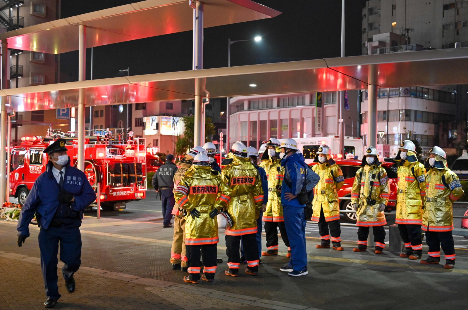 Firefighters gather outside Kokuryo Station after a man injured at least 10 people in a knife and fire attack on a train on the Keio Line in the city of Chofu in western Tokyo on Oct. 31, 2021.  (AFP Photo)