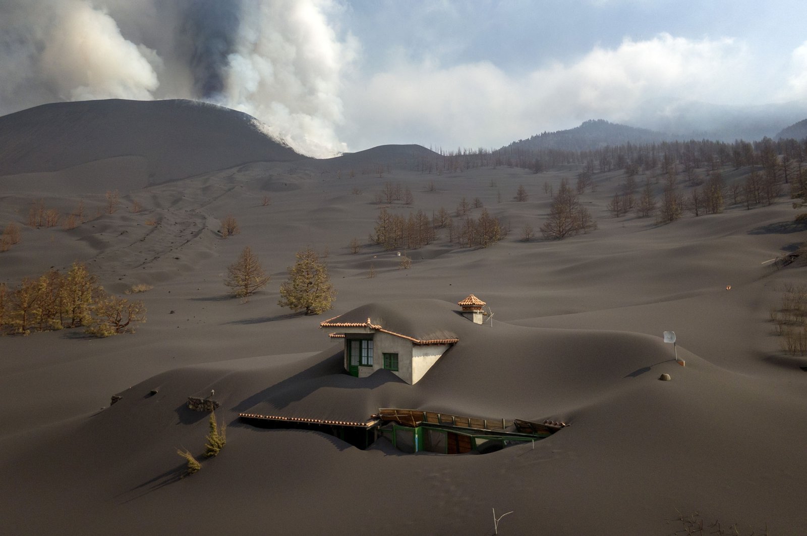 A house is covered by ash from a volcano as it continues to erupt on the Canary island of La Palma, Spain, Oct. 30, 2021. (AP Photo)