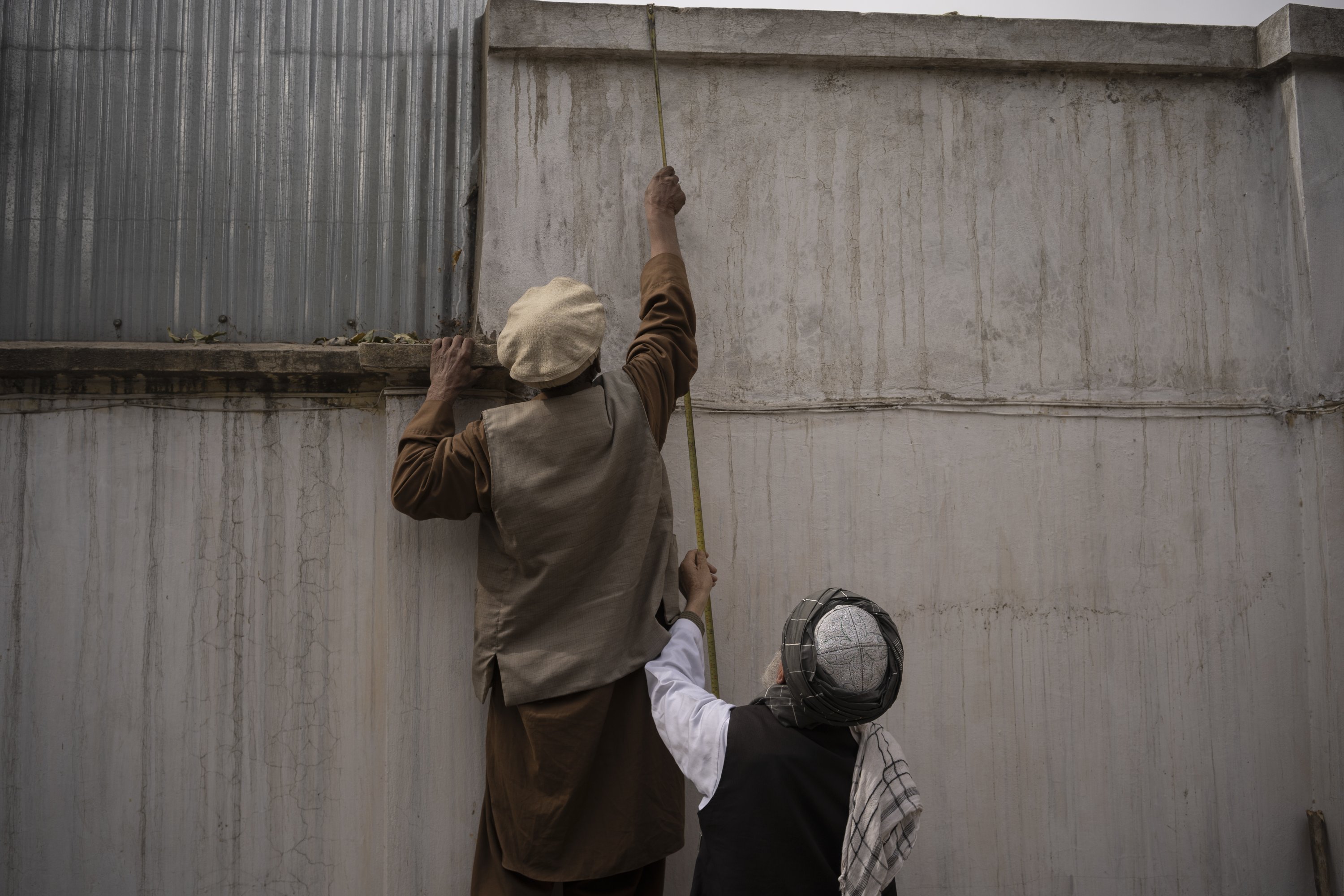 Two men take measurements for the construction of a mosque inside the hospital