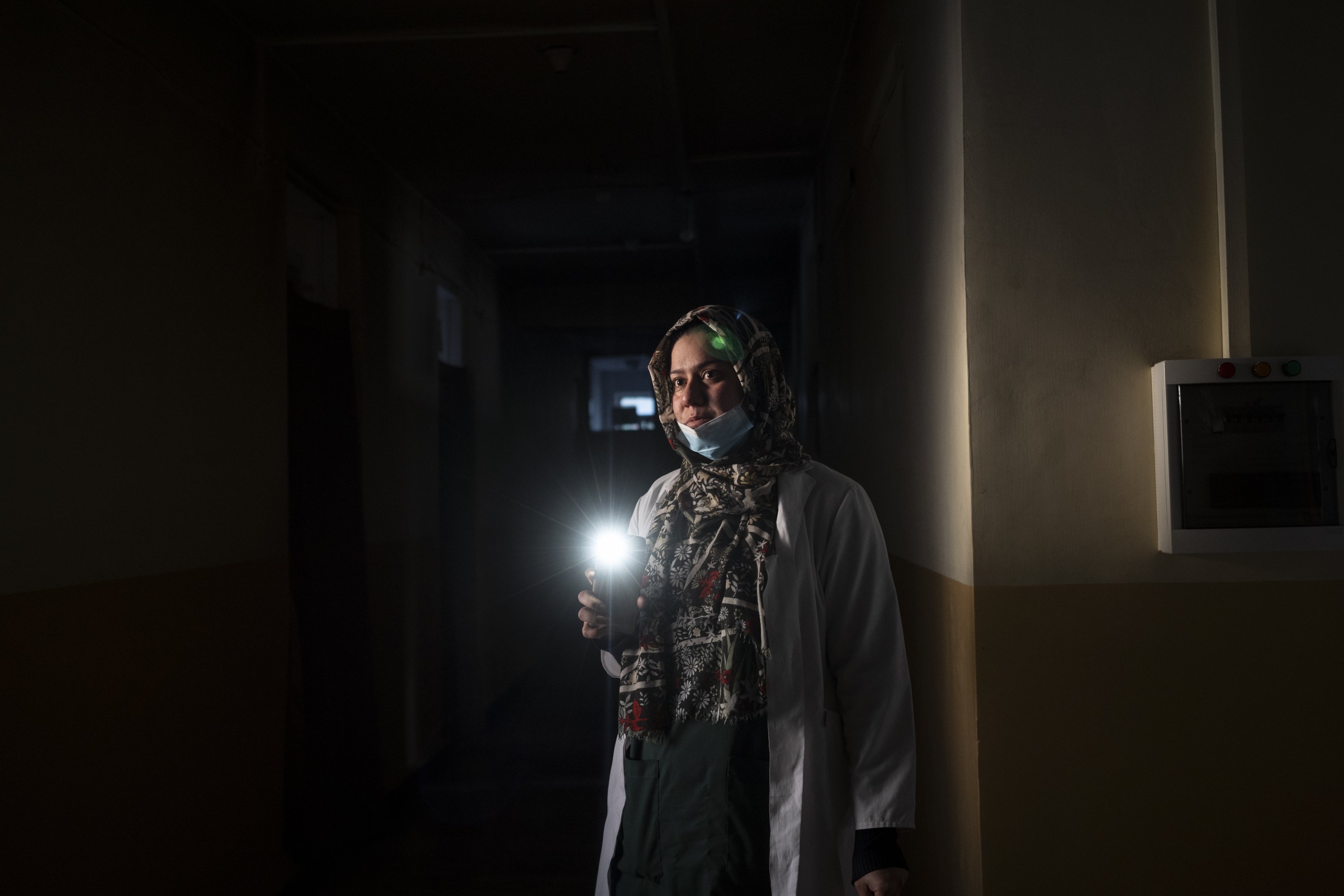 Dr. Elaha Ibrahimi uses her phone as a torch during a power cut inside the hospital in Mirbacha Kot, Afghanistan, Oct. 24, 2021. (AP Photo)