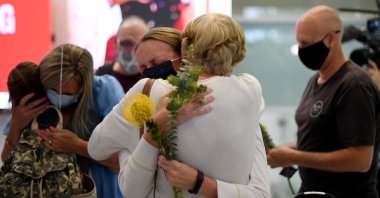 Family members celebrate upon being reunited on arrival at Sydney's International Airport on Nov. 1, 2021, as Australia's international border reopened almost 600 days after a pandemic closure began. (AFP Photo)