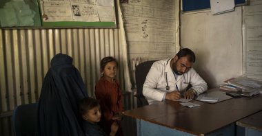 Dr. Gul Nazar writes a prescription for patients in the Mirbacha Kot hospital in Afghanistan, Oct. 25, 2021. (AP Photo)
