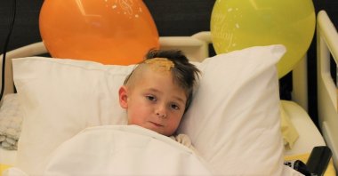 Eduard Costan, a 4-year-old from Romania, can be seen in bed after undergoing surgery in Turkey. (Photo by DHA)