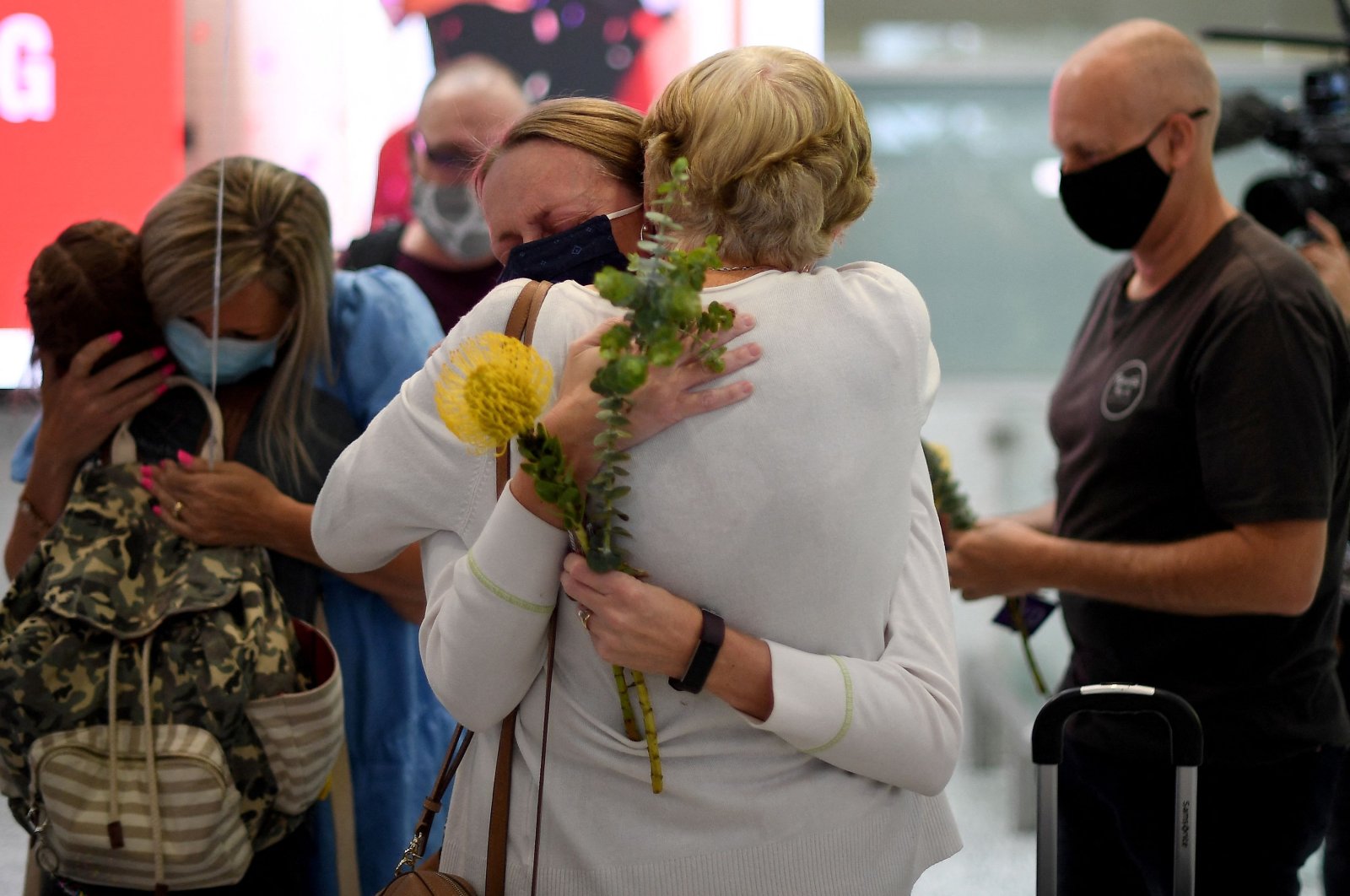 Family members celebrate upon being reunited on arrival at Sydney's International Airport on Nov. 1, 2021, as Australia's international border reopened almost 600 days after a pandemic closure began. (AFP Photo)