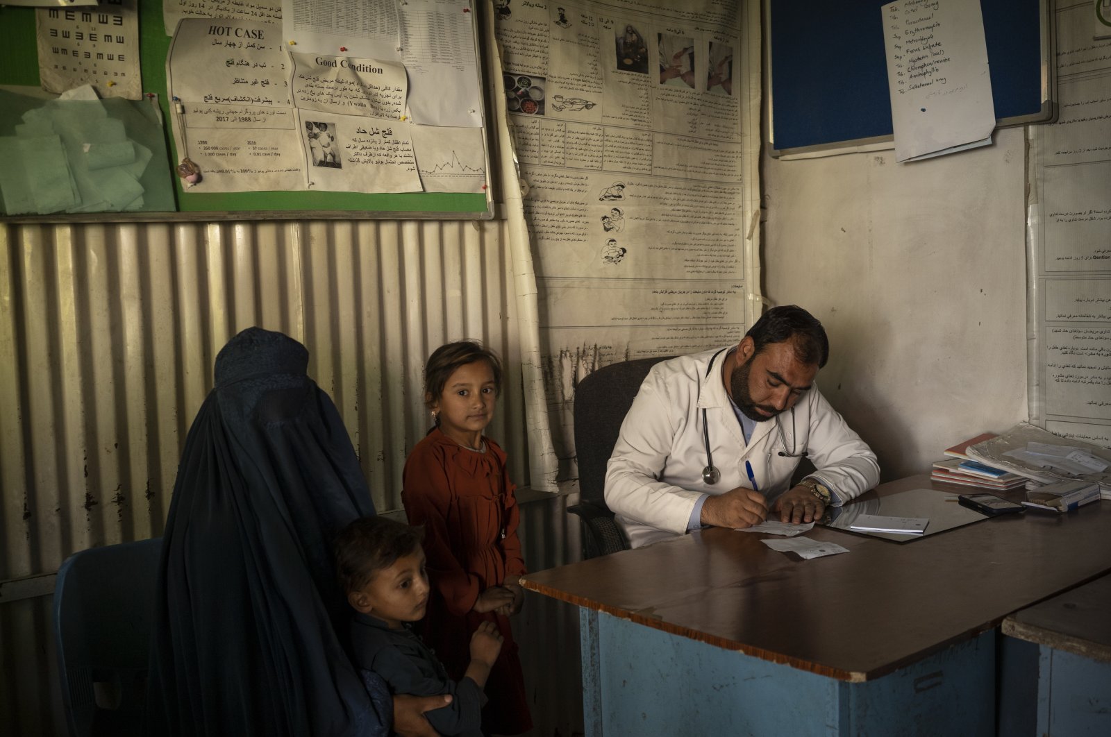 Dr. Gul Nazar writes a prescription for patients in the Mirbacha Kot hospital in Afghanistan, Oct. 25, 2021. (AP Photo)