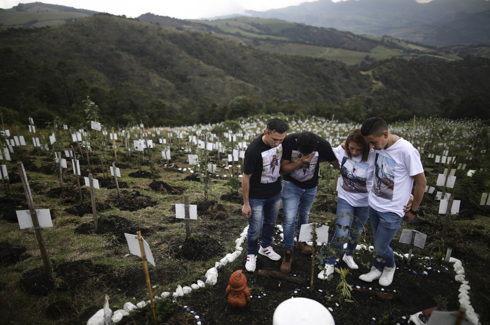 Relatives of Luis Enrique Rodriguez, who died of COVID-19, visit where he was buried on a hill at the El Pajonal de Cogua Natural Reserve, in Cogua, north of Bogota, Colombia, Oct. 25, 2021. (AP Photo)