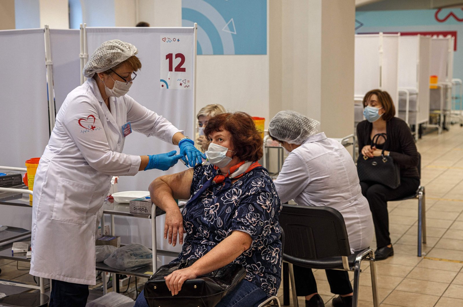 A health care worker administers a dose of Russia's Sputnik V COVID-19 vaccine to a patient at a vaccination center in the GUM State Department store in Moscow, Russia, Oct. 21, 2021. (AFP Photo)