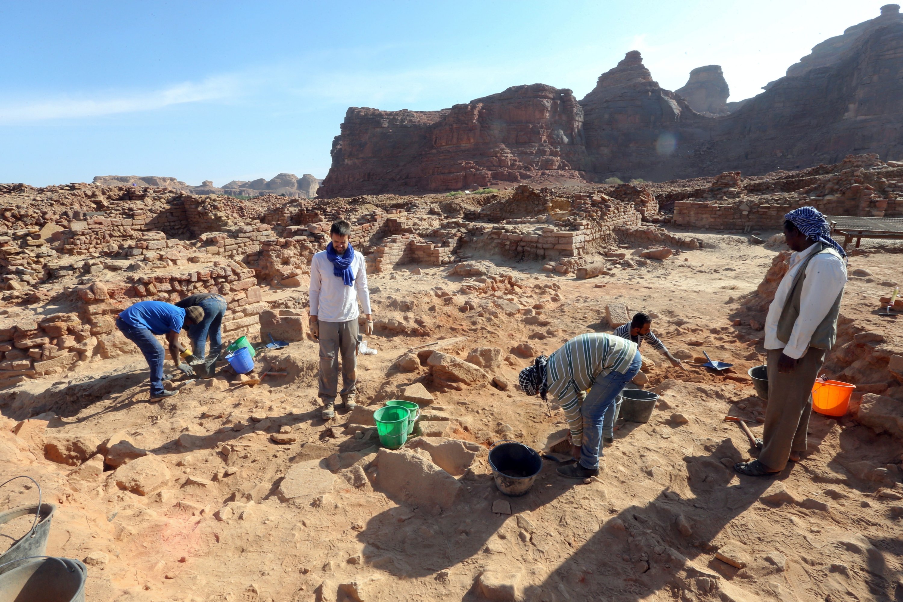 Seorang arkeolog Prancis dan rekan-rekannya dengan hati-hati membersihkan tembikar untuk memeriksa temuan yang diketahui berasal dari peradaban Dadan dan Lihyan tertanggal 1.000 SM, Al-Ula, Arab Saudi, 30 Oktober 2021. (Foto Reuters)