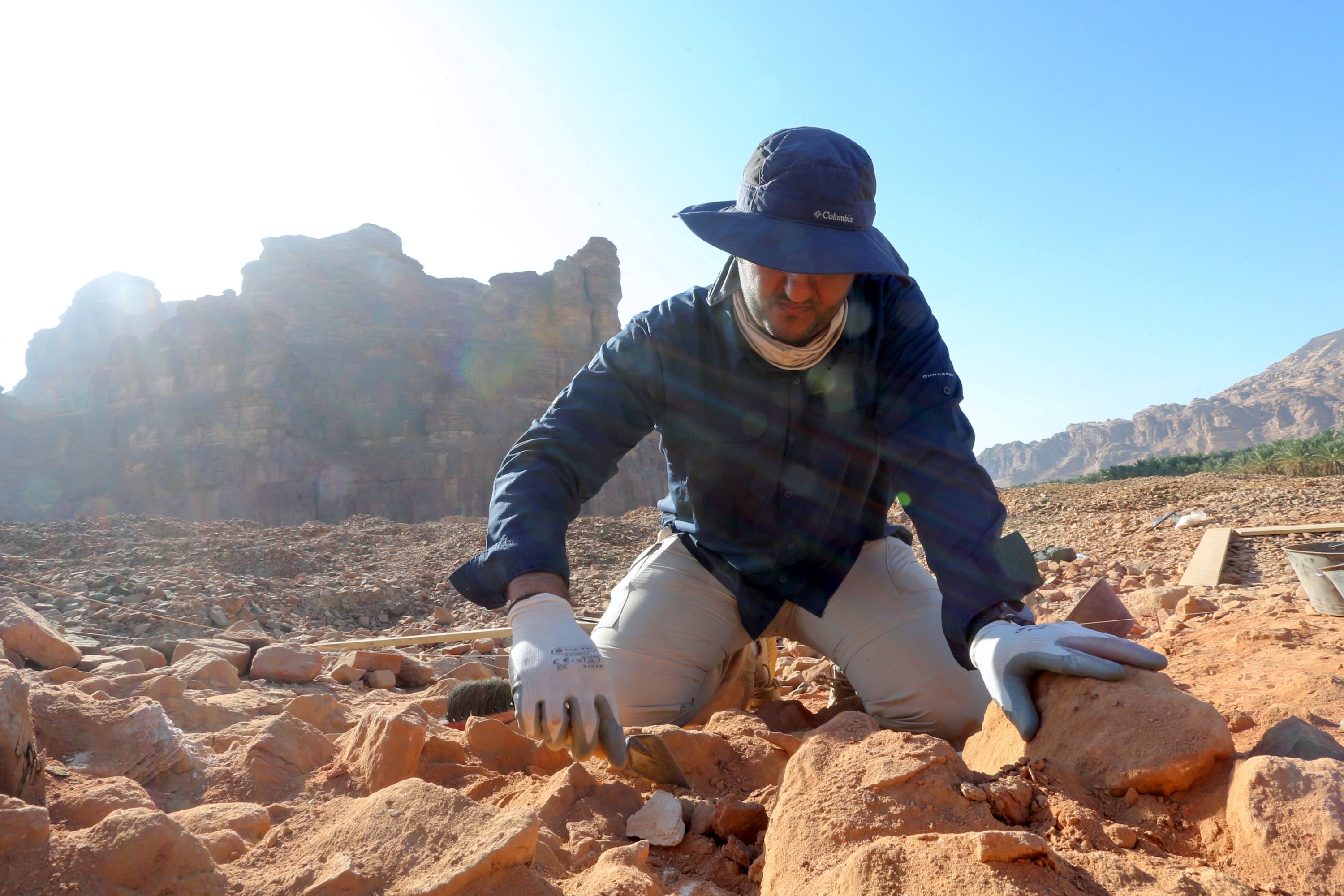 Seorang arkeolog Saudi dengan hati-hati membersihkan tembikar untuk memeriksa temuan yang diketahui berasal dari peradaban Dadan dan Lihyan tertanggal 1.000 SM, Al-Ula, Arab Saudi, 30 Oktober 2021. (Foto Reuters)