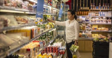 A woman stands in a store selling food in Shanghai, China, Oct. 13, 2021. (EPA Photo)