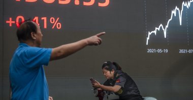 A man walks in front of the screen showing the newest stock exchange and economic data in Shanghai, China, Oct. 7, 2021. (EPA Photo)