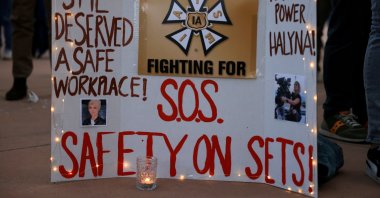 A woman displays a sign calling for workplace safety at a vigil for cinematographer Halyna Hutchins, who died after being accidentally shot by Alec Baldwin on the set of the film "Rust," in Albuquerque, New Mexico, U.S., Oct. 23, 2021. (Reuters Photo)