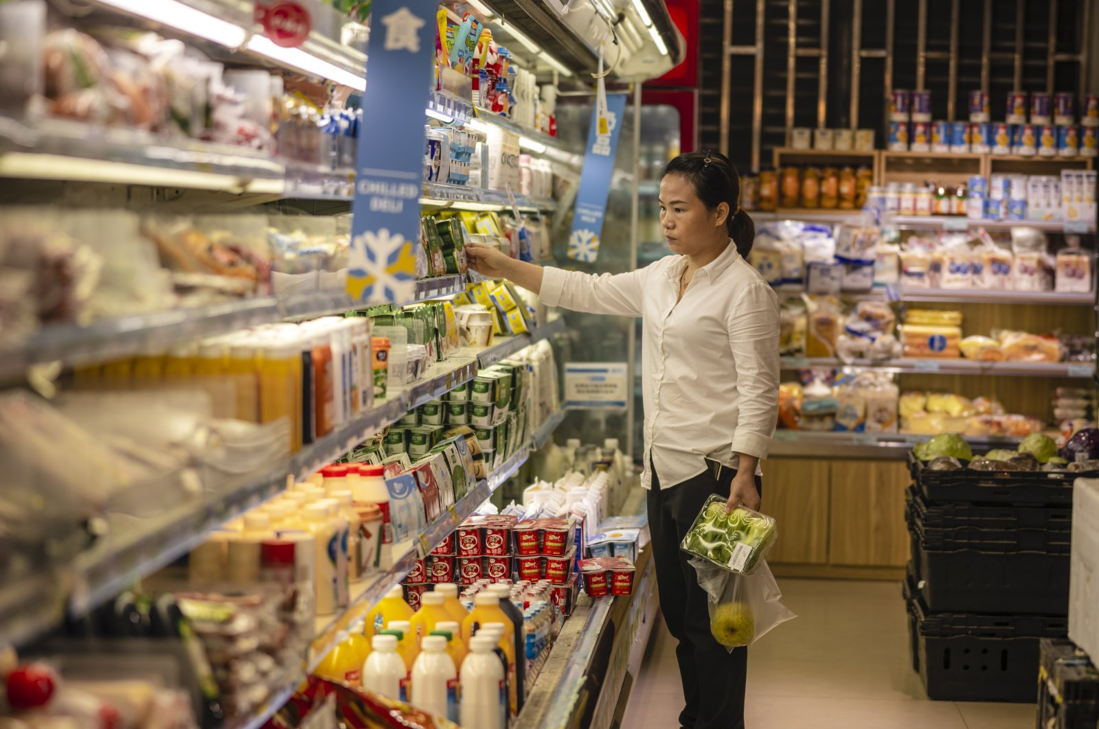 A woman stands in a store selling food in Shanghai, China, Oct. 13, 2021. (EPA Photo)